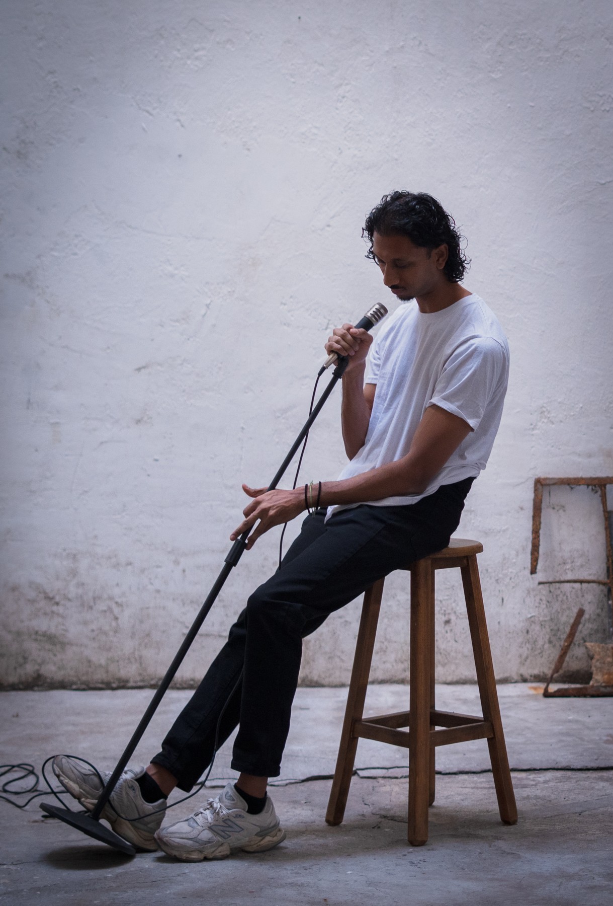 Rah Nimmy seated on a wooden stool during his portrait shoot
